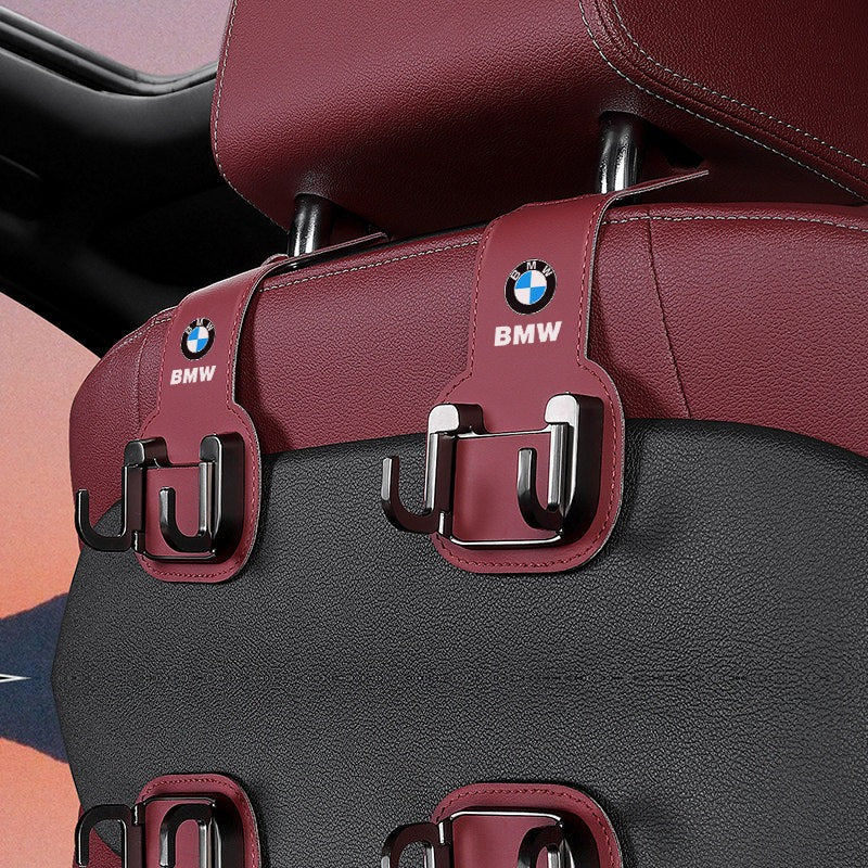 BMW seat back hooks installed on headrest posts, holding items behind the front seat