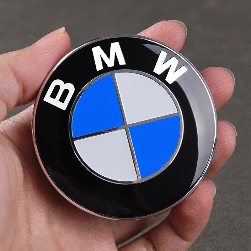 BMW wheel center cap held in hand, close-up of badge detail