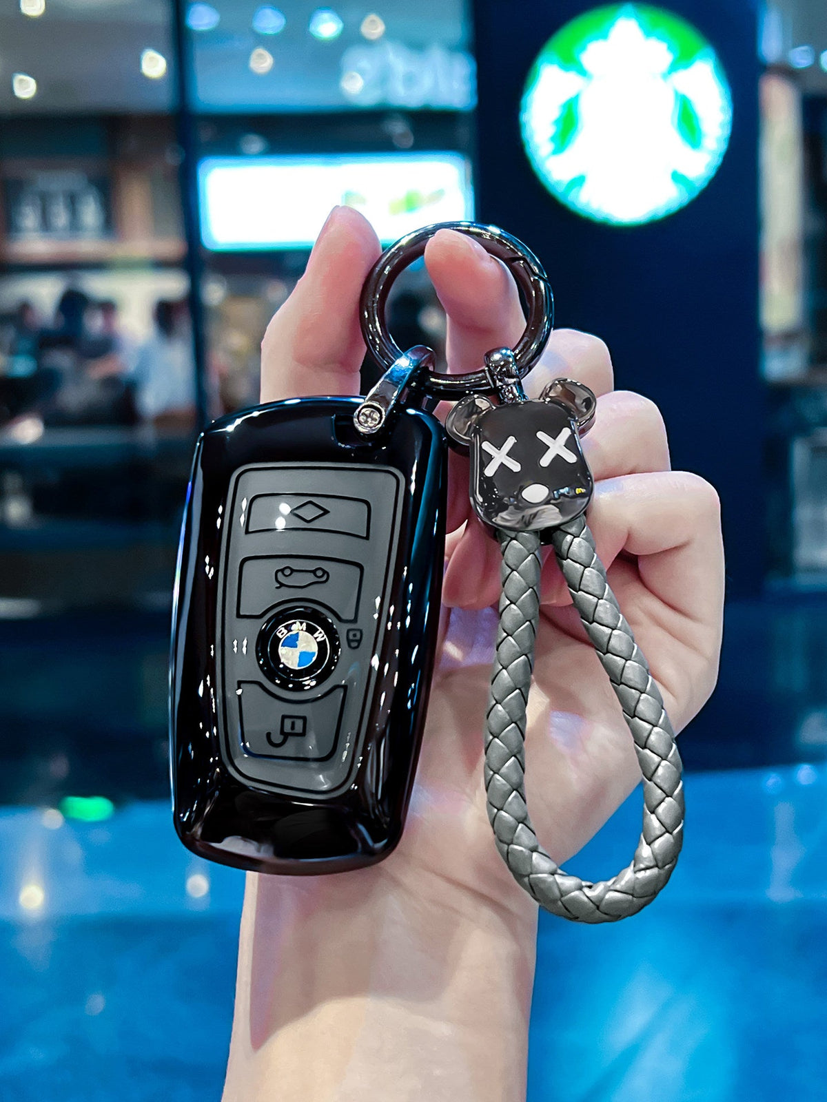 BMW glossy black TPU key sleeve with bear keychain, angled view