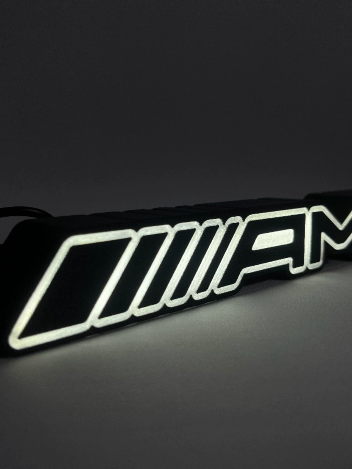 Mercedes-AMG LED emblem lamp close-up of glowing outline