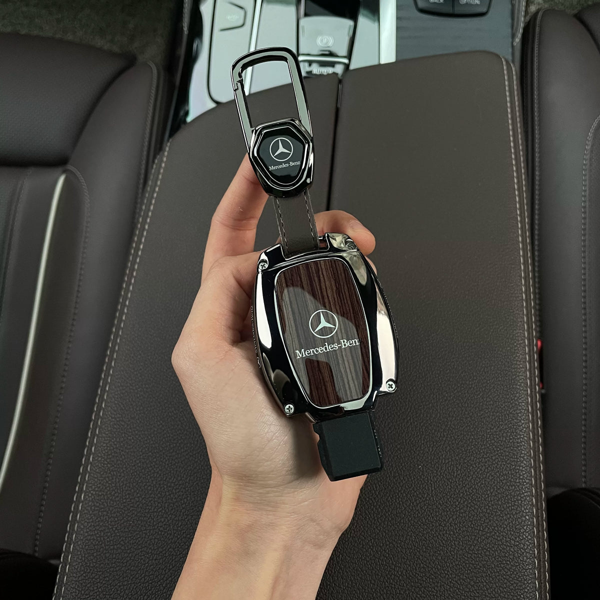 Brown wood grain Mercedes-Benz key case with leather tab carabiner