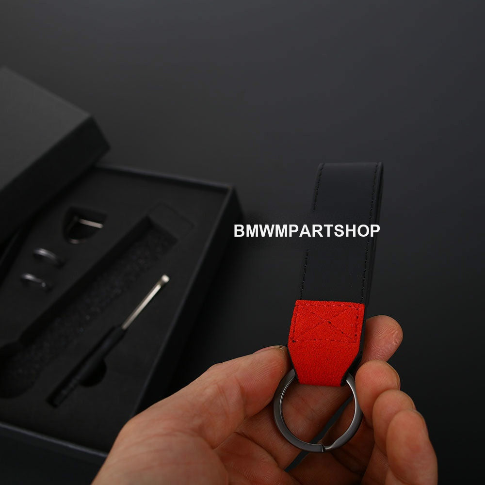 BMW M suede keychain with red and black Alcantara strap held in hand
