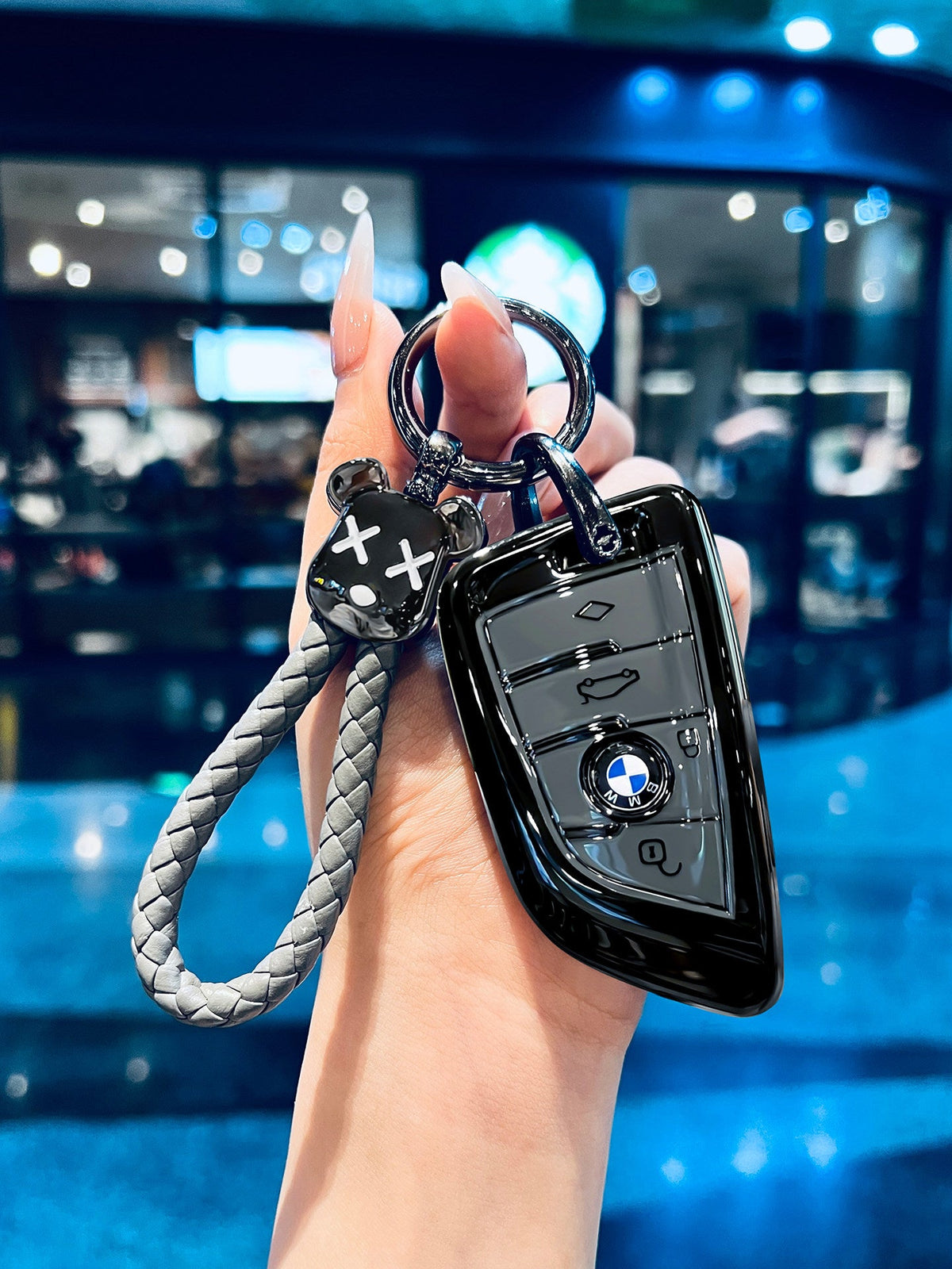 BMW glossy black TPU key fob case with braided rope keychain held in hand