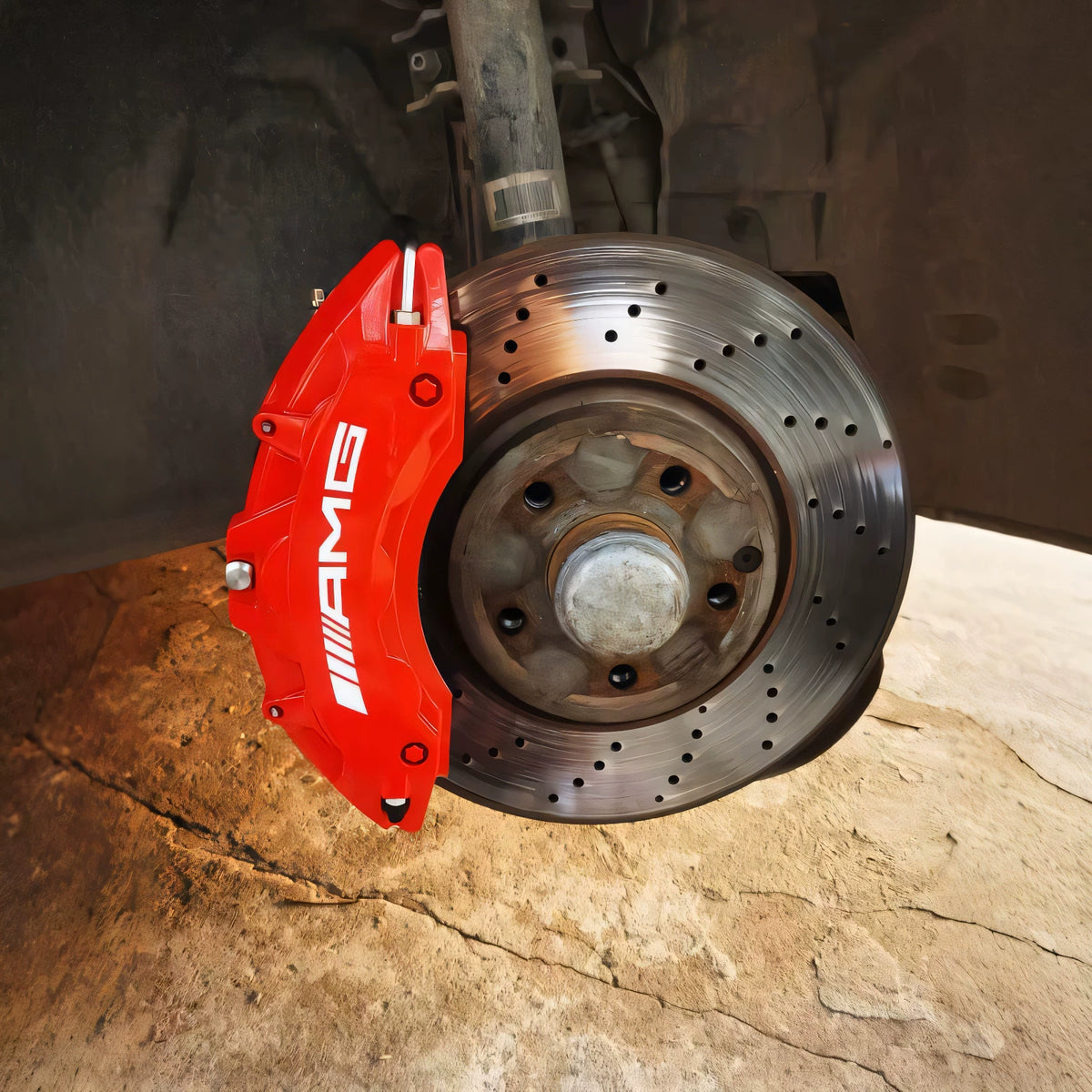 Red Mercedes-AMG brake caliper cover fitted on a drilled brake disc