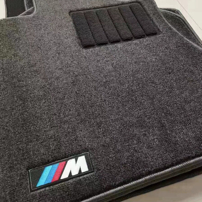 BMW custom-fit velvet floor mat close-up with non-slip backing texture