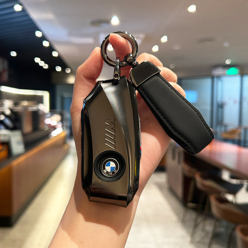 BMW key case gunmetal black with black cord strap keychain held in hand