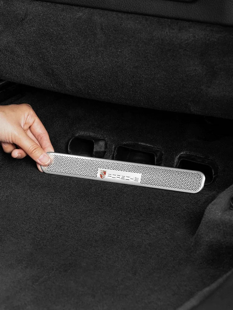 Fitting the silver under-seat air vent cover with Porsche crest