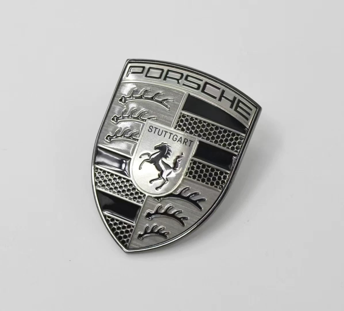 Porsche smoked gray crest hood emblem – angled view