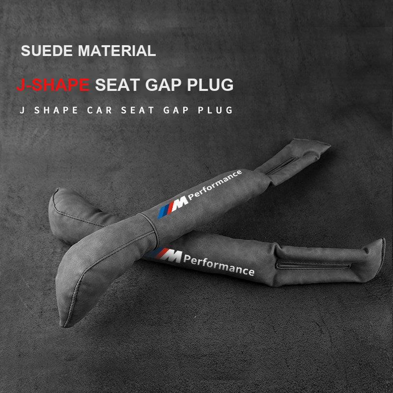 Pair of BMW suede seat gap plugs with M Performance stripe on textured background