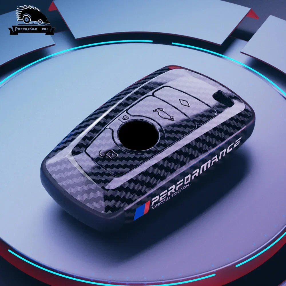 BMW carbon fiber key case with blue keychain, close-up
