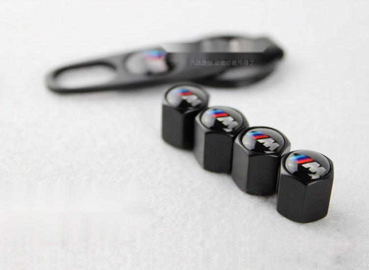 BMW M black tire valve caps close-up with alloy construction