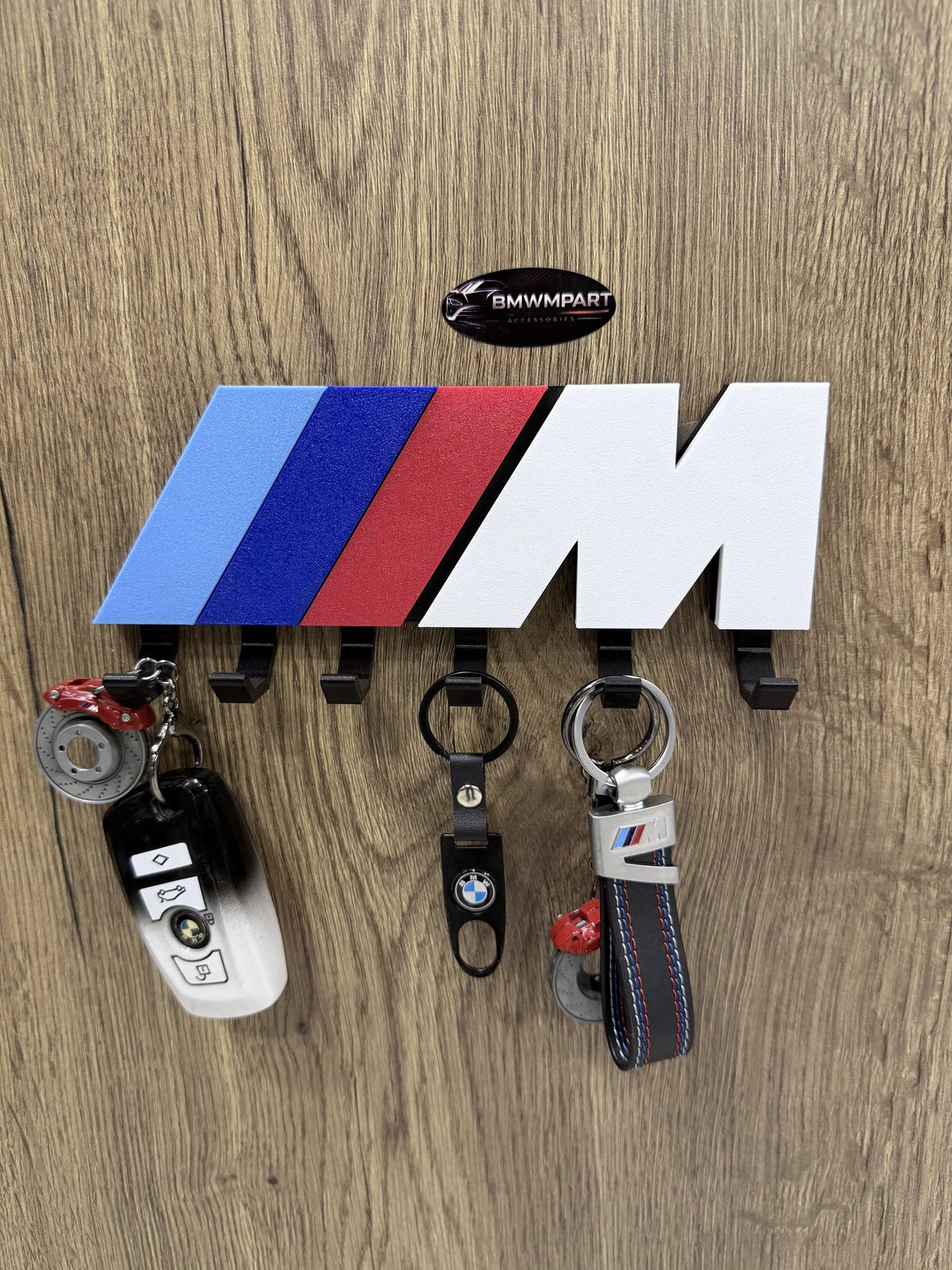 BMW M Stripe wall key holder with BMW keys and keychains hanging on 6 hooks