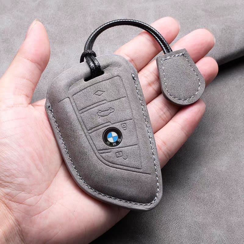 BMW leather key fob cover in gray, shown held in hand for size reference
