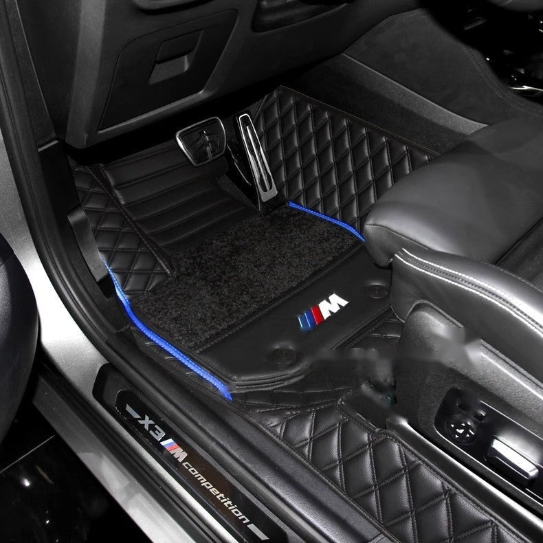 BMW custom floor mat installed in car footwell with blue trim stitching