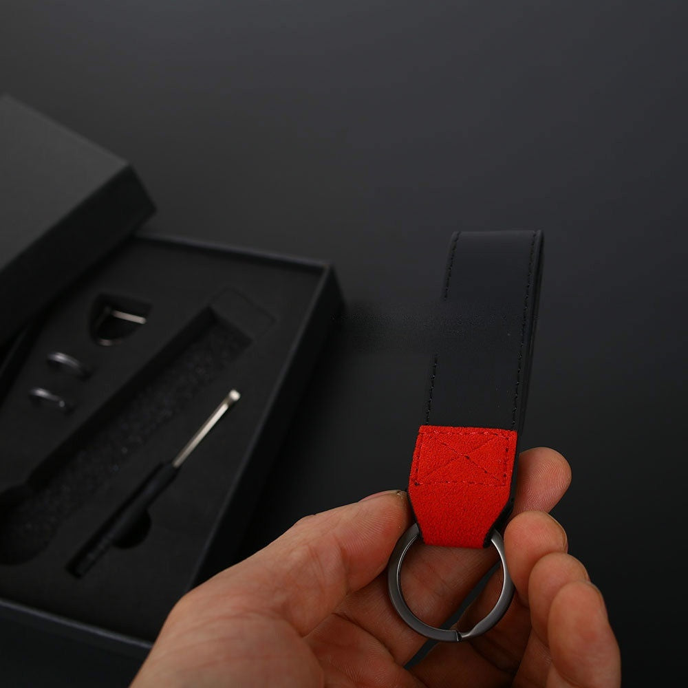 BMW M suede keychain with red and black Alcantara strap held in hand