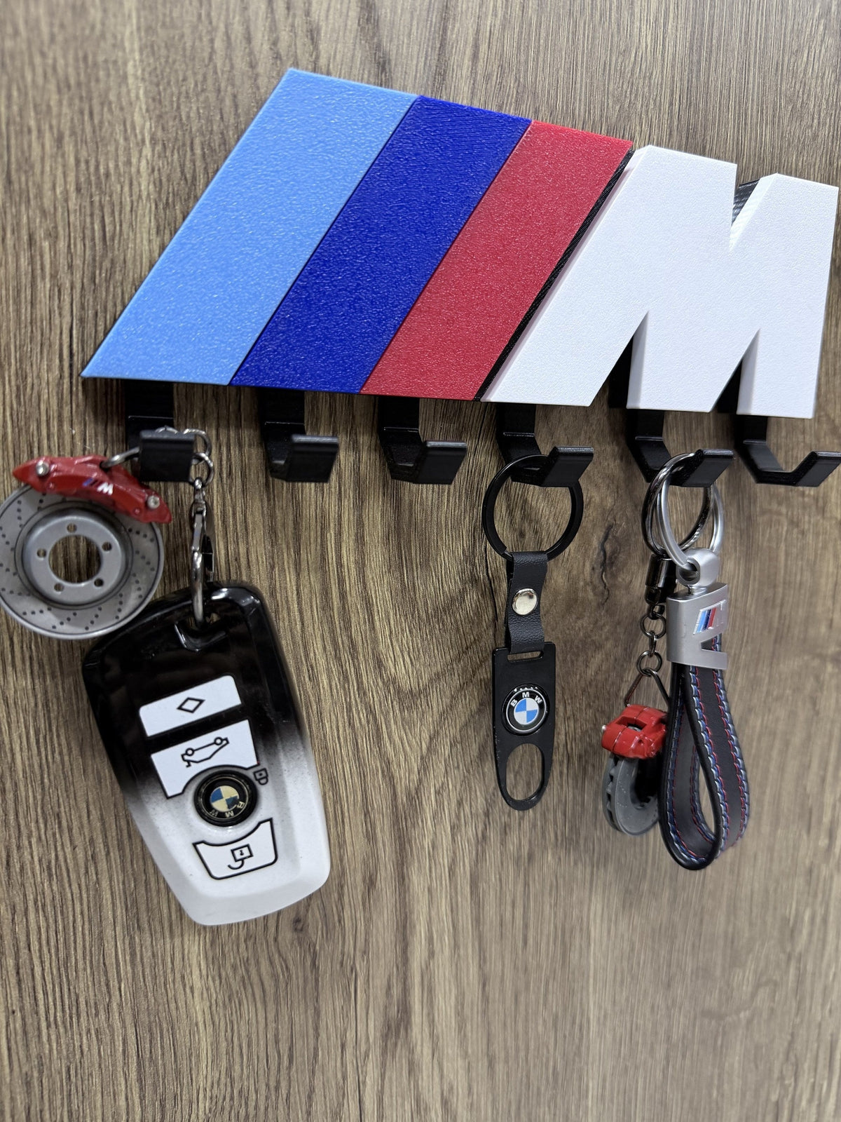 Close-up of BMW M color key rack with BMW leather keychain and brake caliper keychain