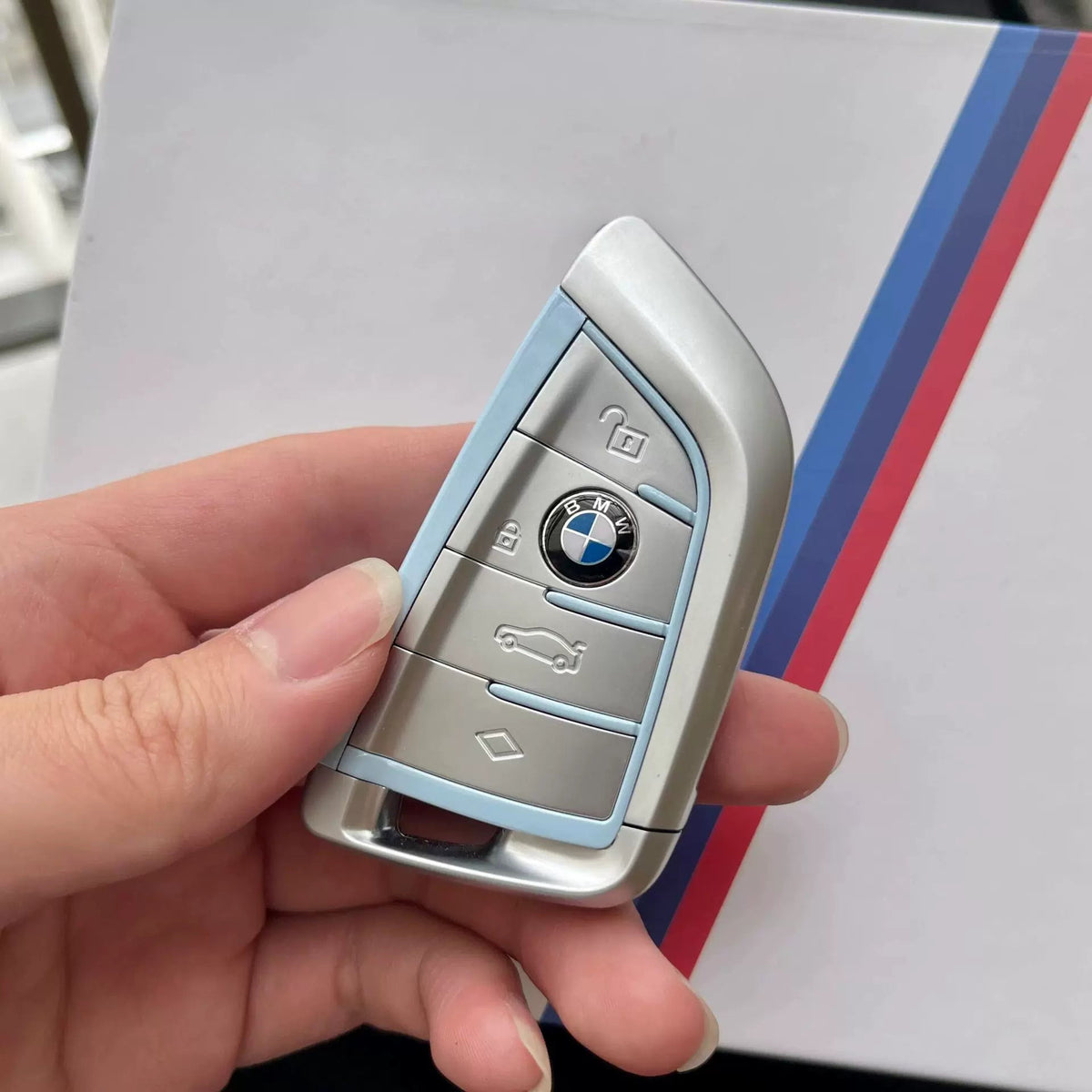 BMW blade key housing in Aqua Blue held in hand, G-Series version