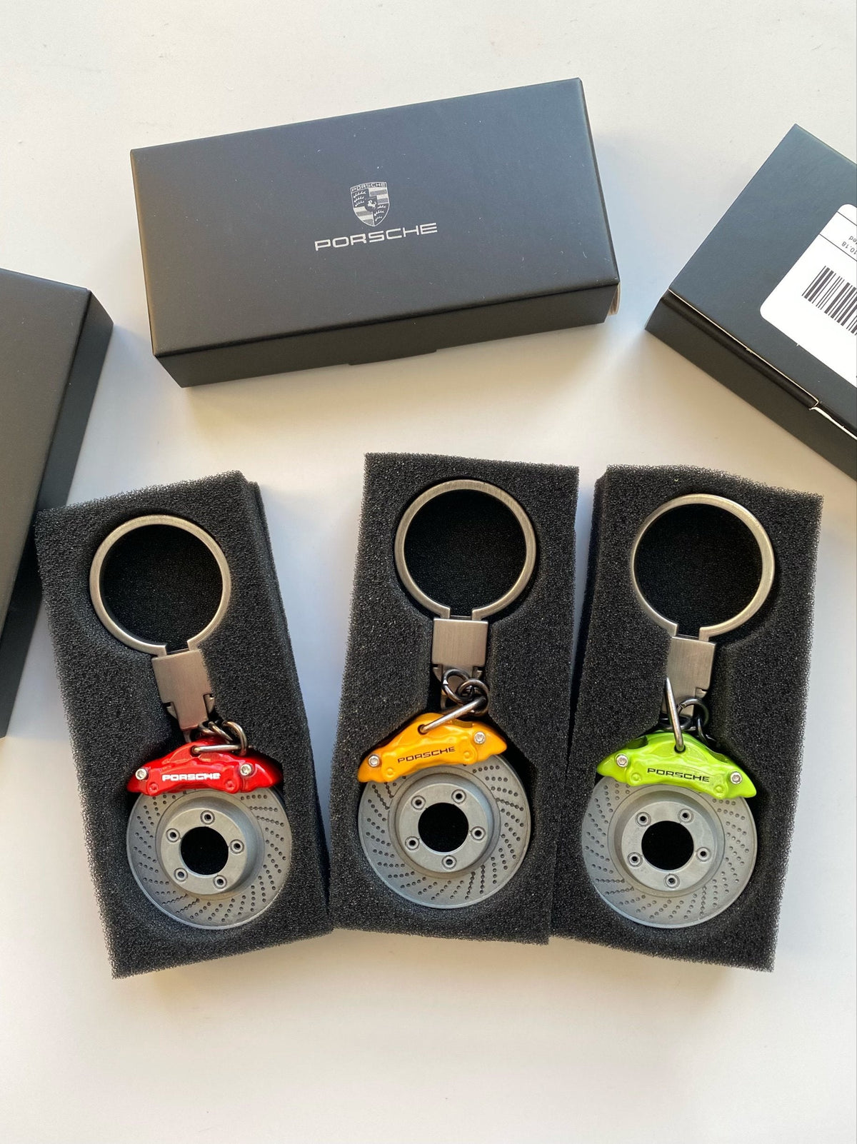 Porsche brake disc keychains in red, yellow and lime green with gift boxes