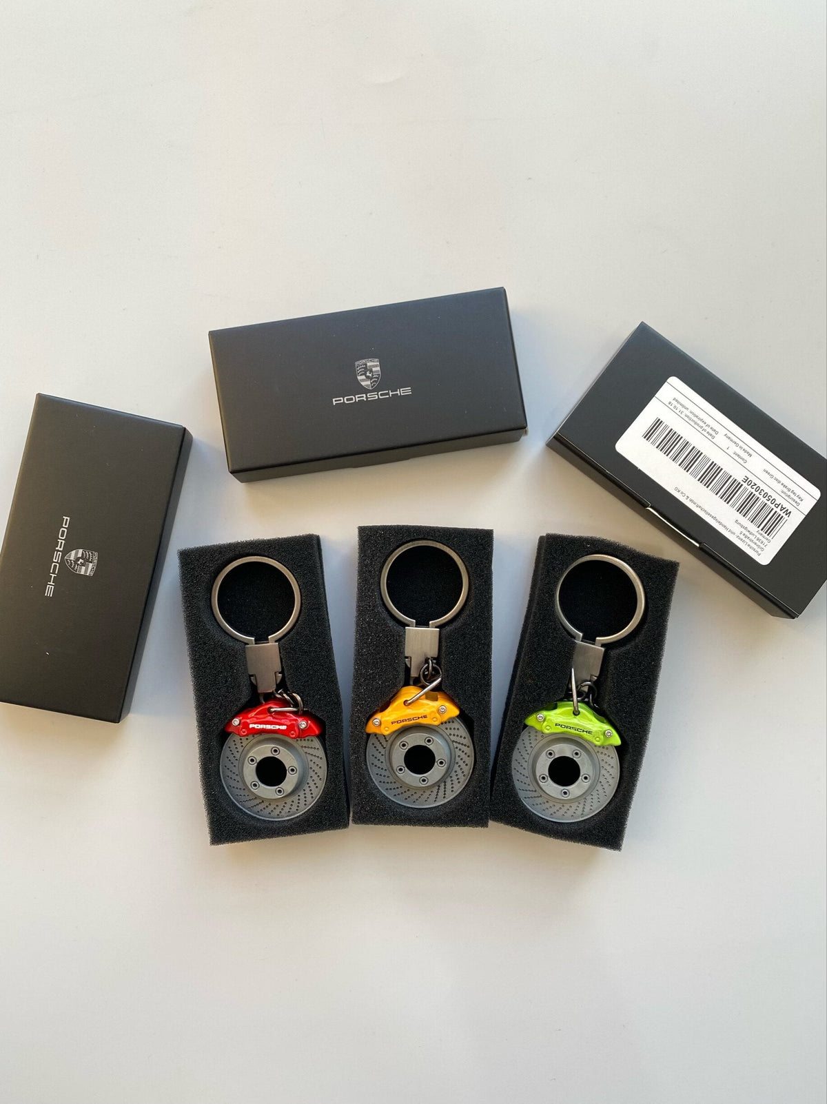 Three Porsche brake caliper keychains with Porsche gift boxes