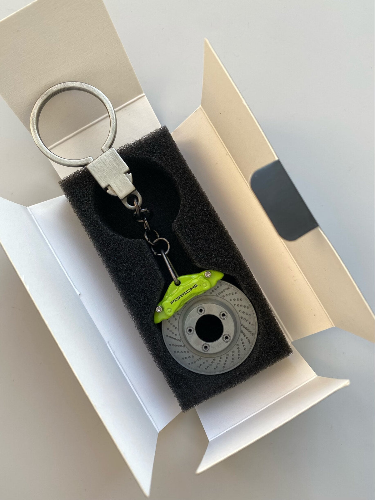 Porsche brake disc keychain with lime green caliper in gift box