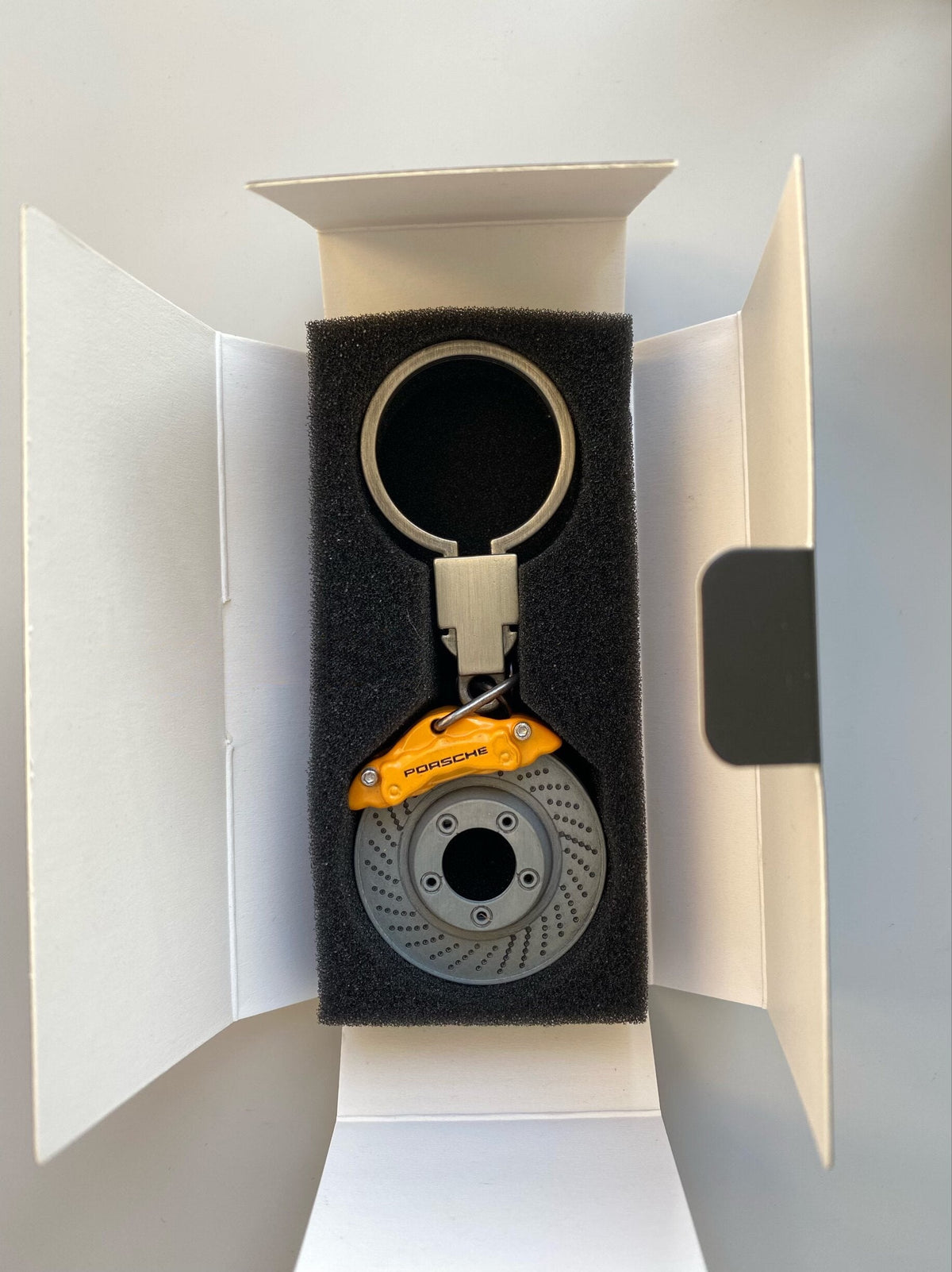 Porsche brake disc keychain with yellow caliper in gift box