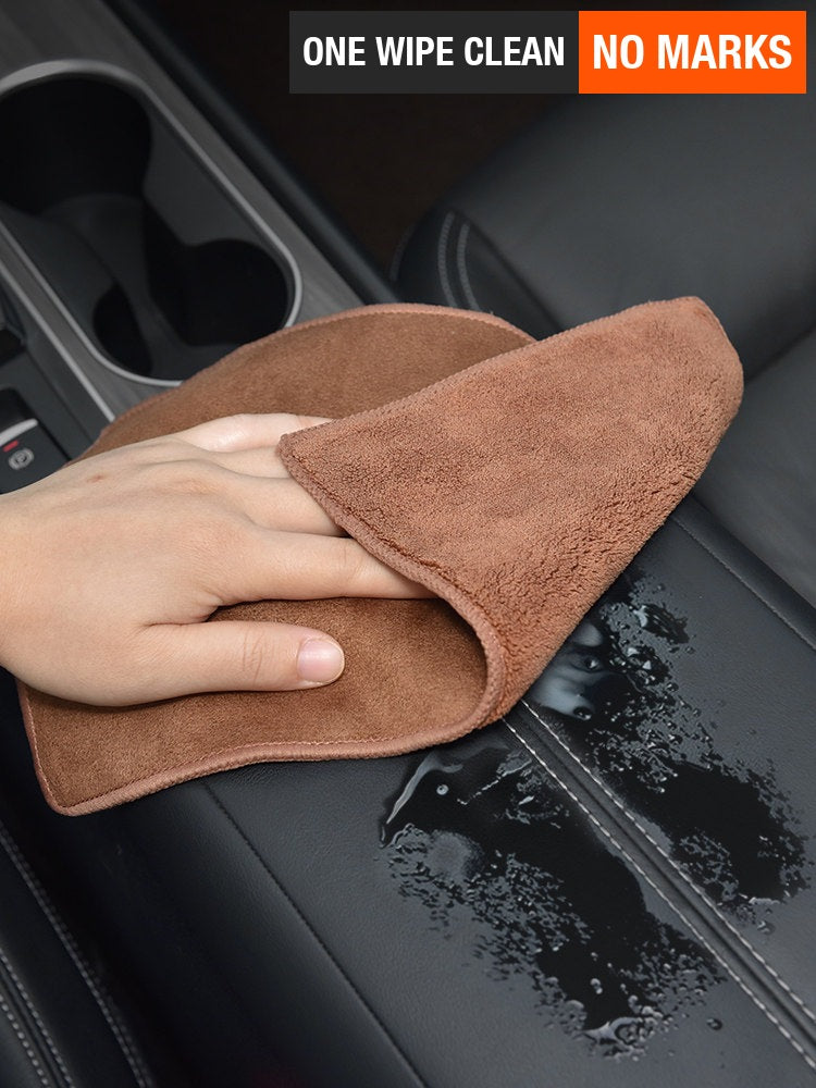Brown Porsche microfiber towel wiping water off a leather console