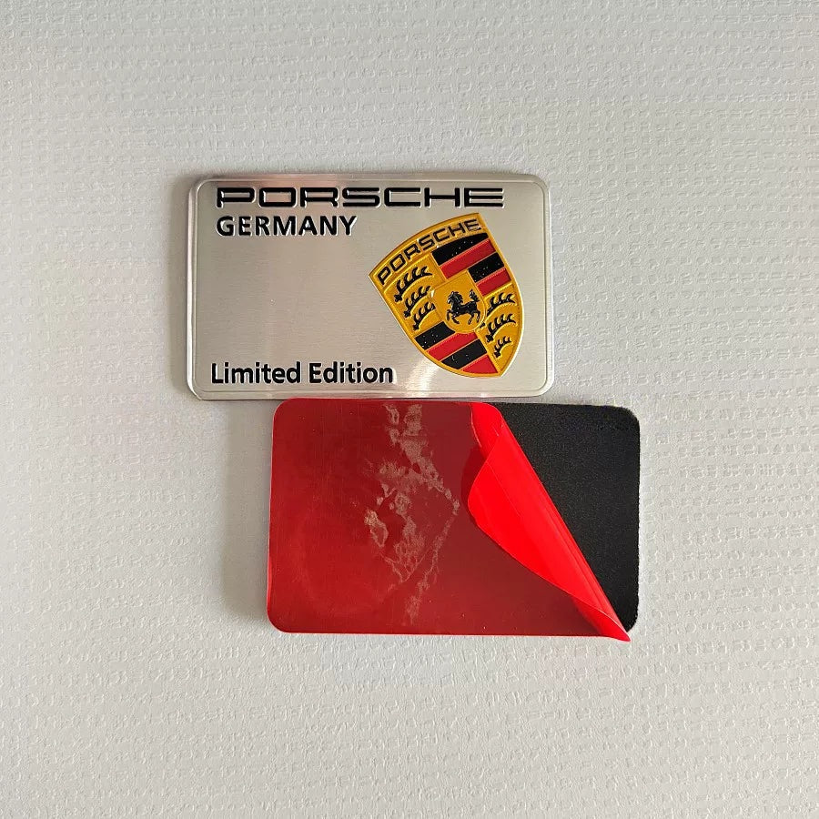 Silver Porsche Limited Edition badge with red adhesive backing film